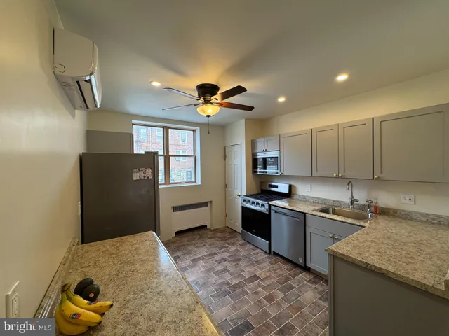 a kitchen with granite countertop a sink stainless steel appliances and cabinets
