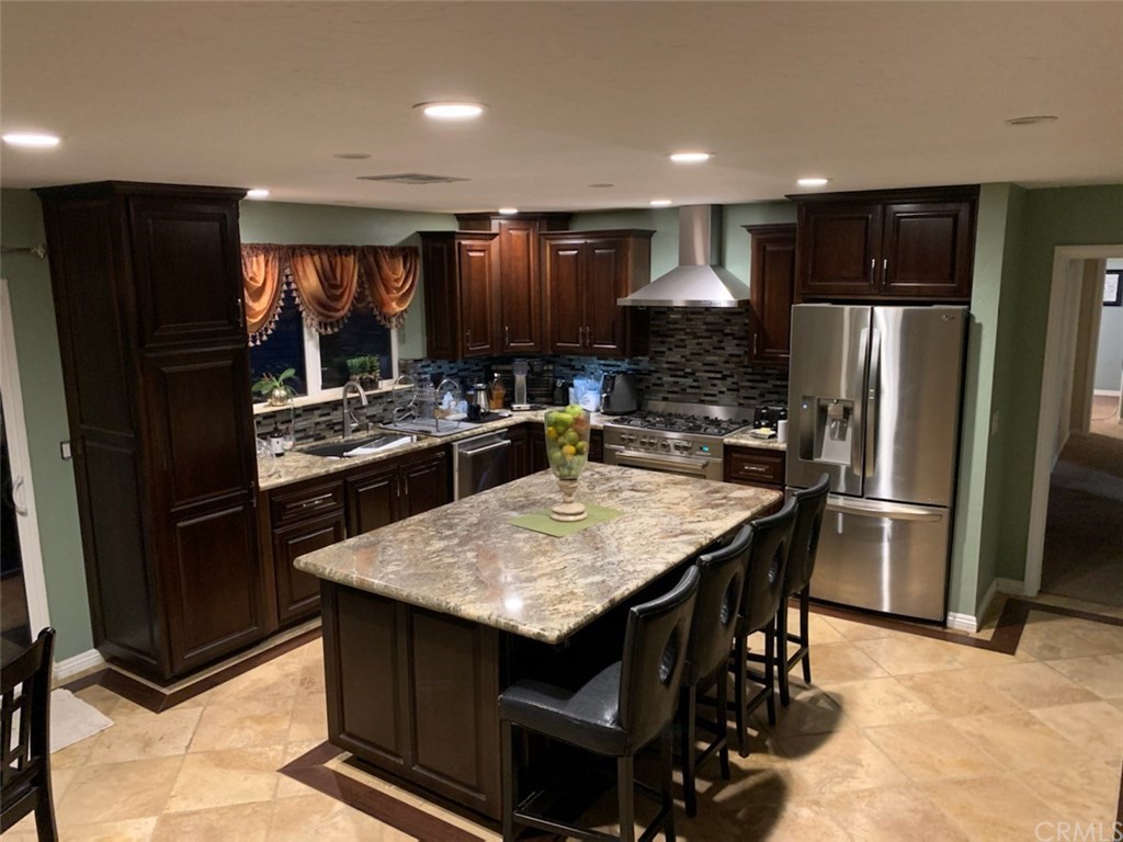 a kitchen with stainless steel appliances granite countertop a refrigerator stove microwave and sink