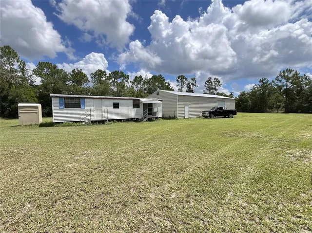 a view of a house with yard and sitting area