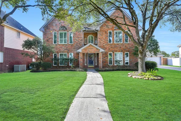 a front view of a brick house with a yard
