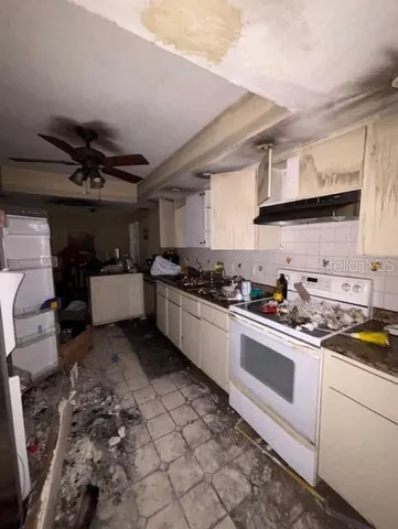a kitchen with a stove a sink and cabinets