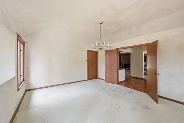 a view of a big room with windows and chandelier