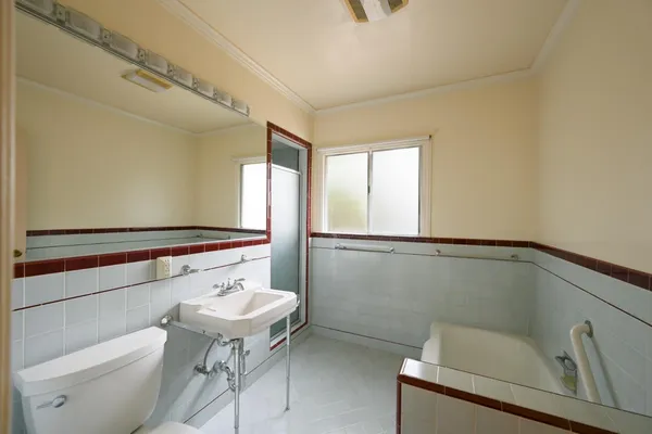 a bathroom with a toilet a sink and mirror