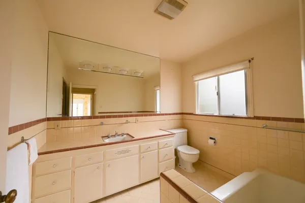 a bathroom with a sink a toilet and a mirror