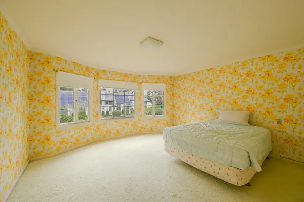 a spacious bedroom with a bed and painting on the wall