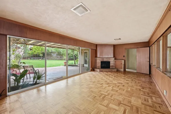 a view of an empty room with a fireplace and a window