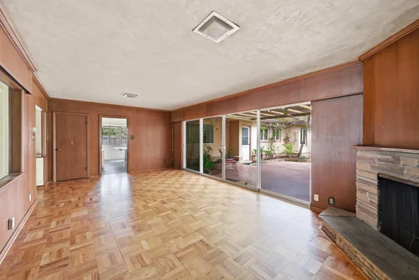 a view of an empty room with window and fire place