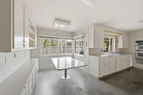 a large white kitchen with a large window