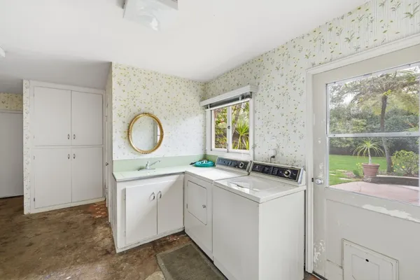 a room with a stove a sink and a mirror