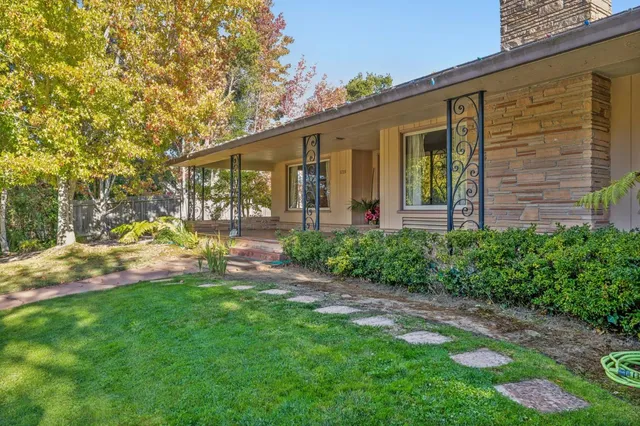 a view of a house with a yard and sitting area