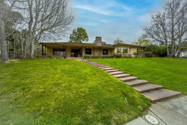 a front view of a house with a garden