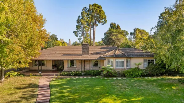 a front view of a house with a garden