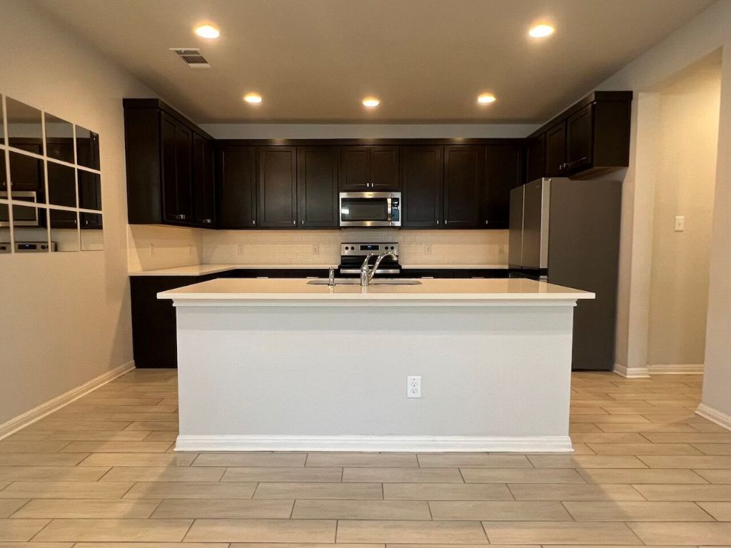 124 Old Stagecoach Road Jarrell, TX 76537 - Photo 8 of 40 a view of kitchen with stainless steel appliances granite countertop wooden cabinets and a sink