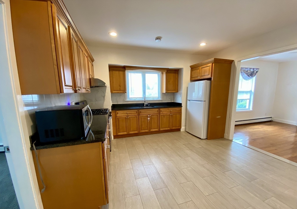 21 Heldun Street, Unit 2 Boston, MA 02132 - Photo 4 of 19 a kitchen with stainless steel appliances granite countertop a refrigerator a stove and a sink