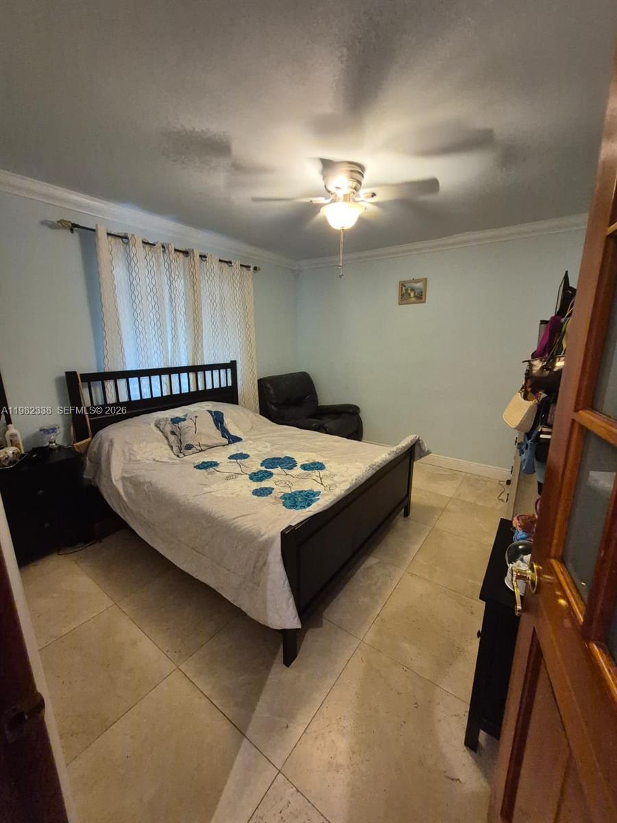 14530 Southwest 110th Street Miami, FL 33186 - Photo 27 of 45 a living room with a bed furniture and a ceiling fan