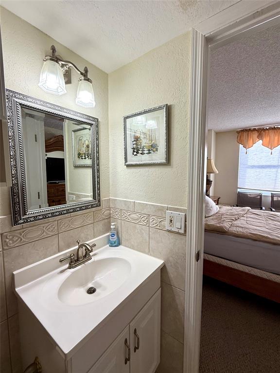 101 Briny Avenue, Unit 2604 Pompano Beach, FL 33062 - Photo 14 of 31 a en suite bathroom with a sink and a mirror