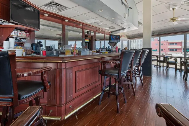 a kitchen with stainless steel appliances granite countertop a table chairs and wooden floors