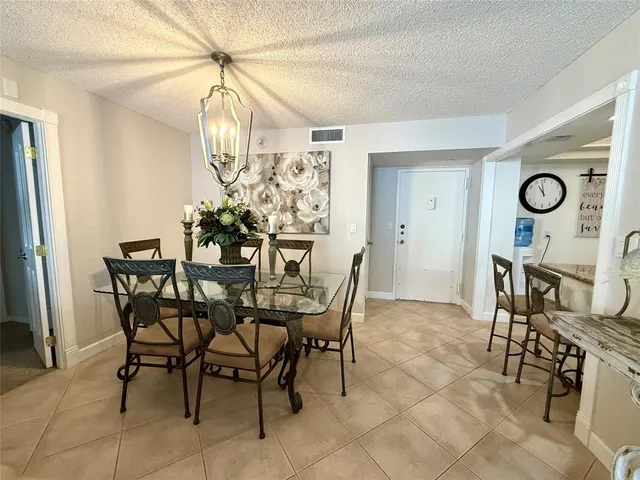a view of a dining room and kitchen with furniture and a chandelier