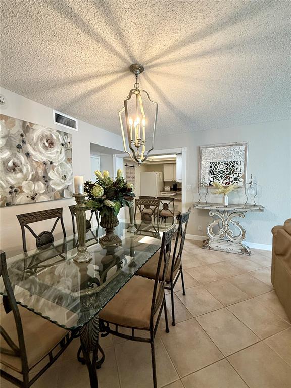 101 Briny Avenue, Unit 2604 Pompano Beach, FL 33062 - Photo 5 of 31 a dining room filled chandelier and wooden floor