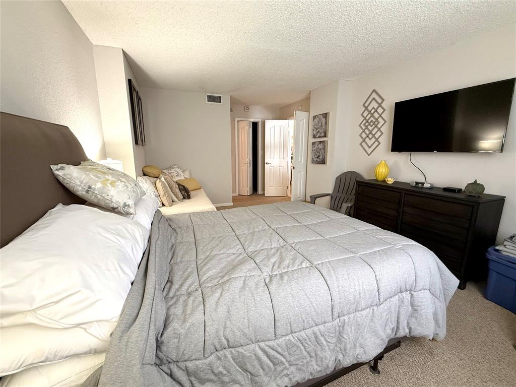 101 Briny Avenue, Unit 2604 Pompano Beach, FL 33062 - Photo 10 of 31 a bedroom with a bed and a flat screen tv