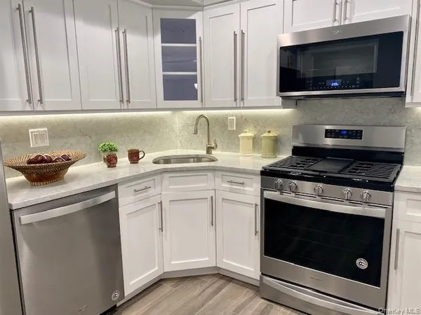 a kitchen with white cabinets and appliances