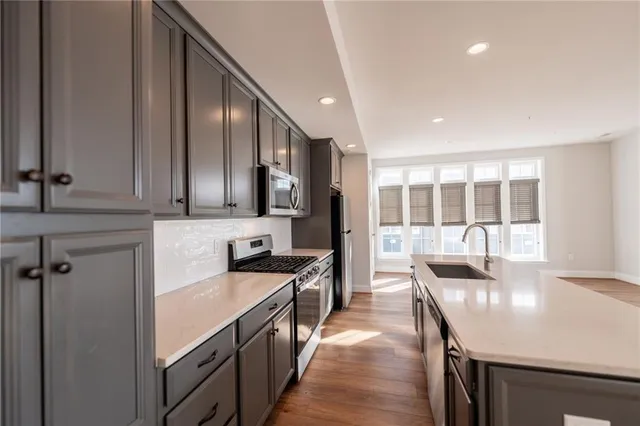 a kitchen with stainless steel appliances granite countertop a sink stove and cabinets