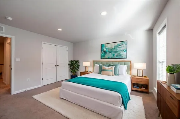 a bedroom with a large bed and a potted plant