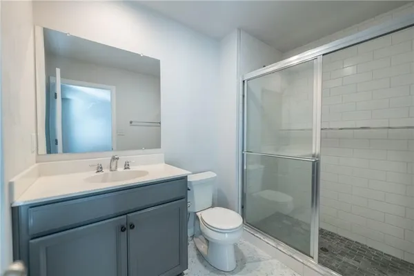 a bathroom with a sink a toilet and shower