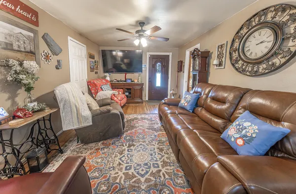a living room with furniture a clock and a chandelier