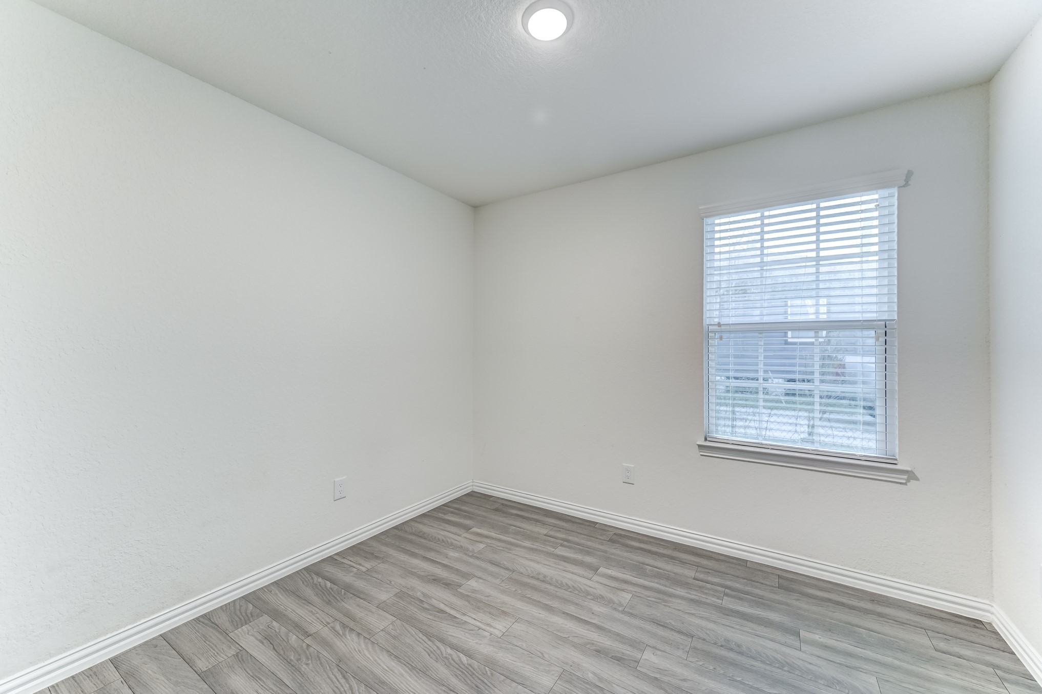 7925 Way Street, Unit A Houston, TX 77028 - Photo 19 of 29 an empty room with wooden floor and windows
