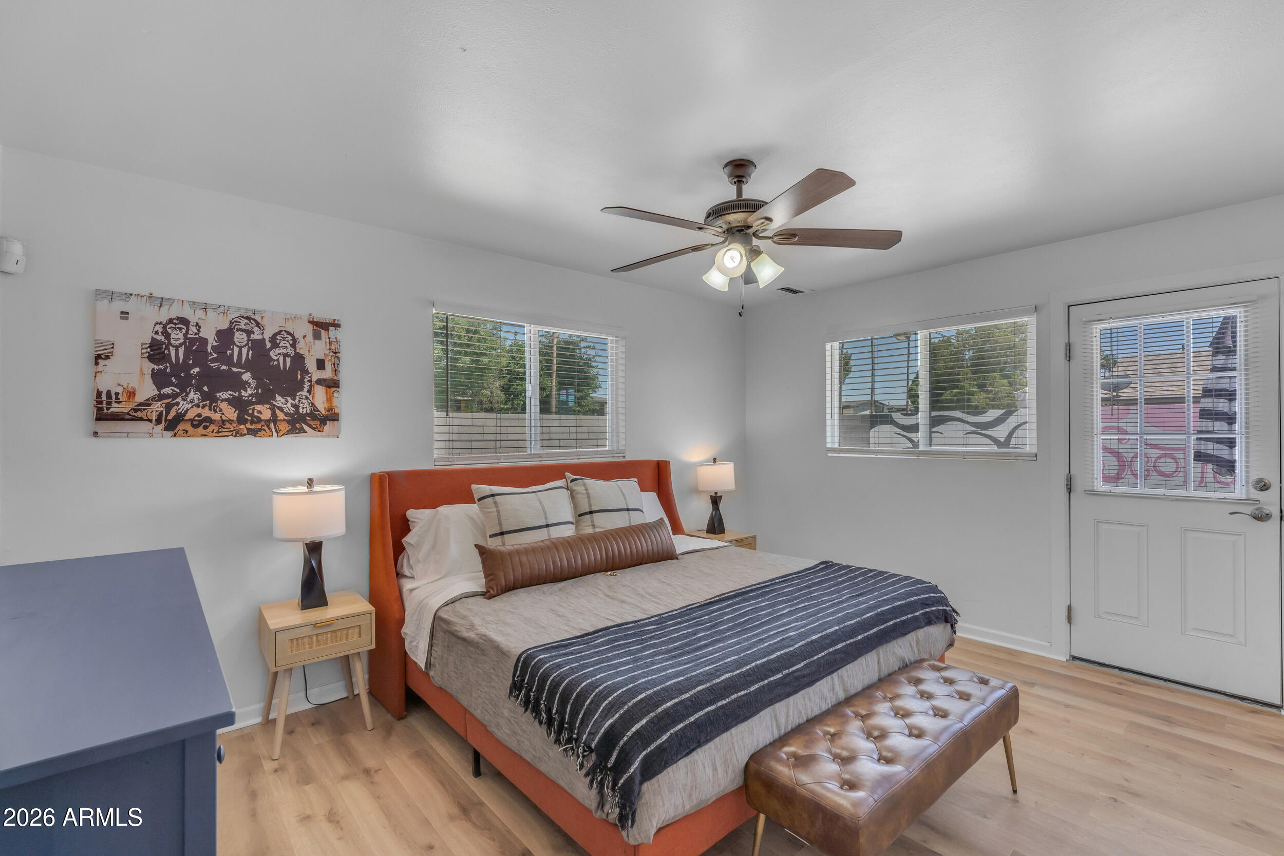 6943 East Granada Road Scottsdale, AZ 85257 - Photo 8 of 19 a bedroom with a large bed a chandelier and a window