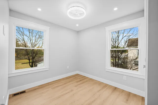 a view of an empty room with wooden floor