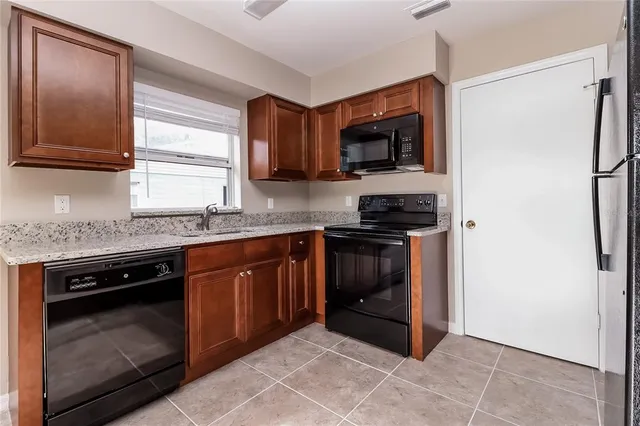 a kitchen with stainless steel appliances granite countertop a stove a microwave and a refrigerator