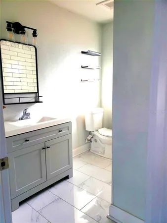 a bathroom with a toilet a sink and mirror