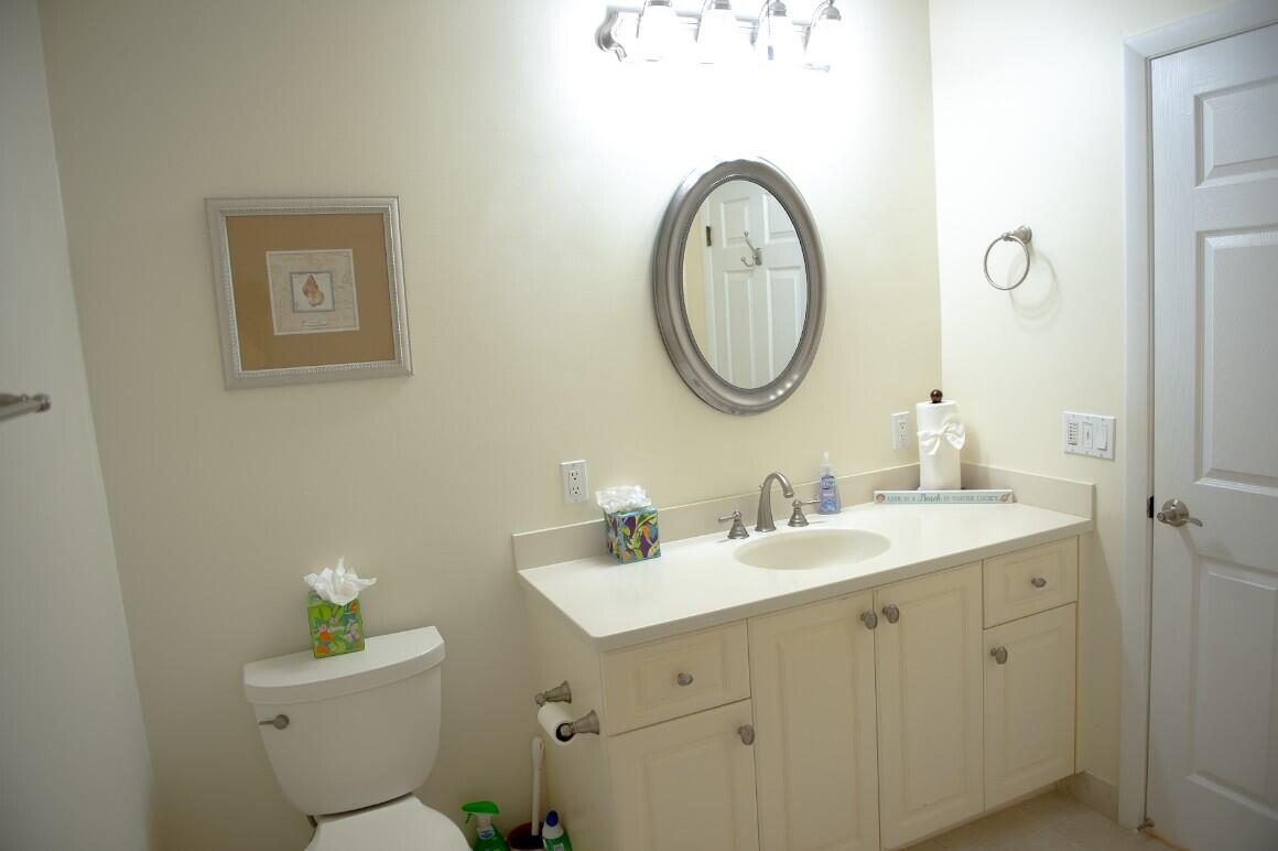 114 Beach Summit Court Jupiter, FL 33477 - Photo 30 of 32 a bathroom with a toilet sink and mirror