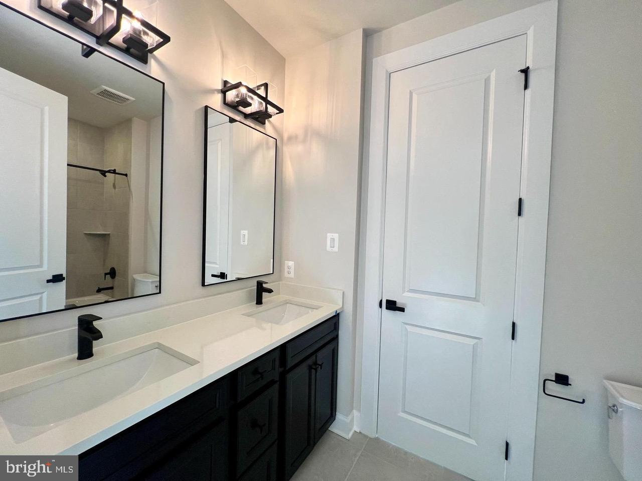 234 Coffman Drive Exton, PA 19341 - Photo 8 of 17 a bathroom with a double vanity sink a mirror and a shower