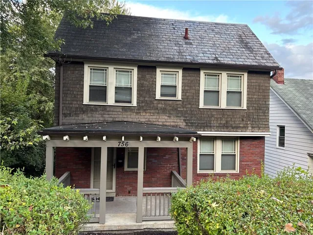 a front view of a house with a garden