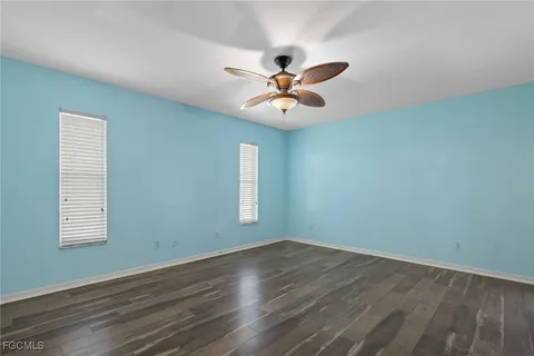 a view of a room with wooden floor and a ceiling fan