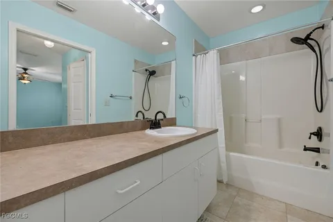a bathroom with a granite countertop sink a mirror and a bathtub