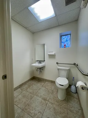 a bathroom with a toilet a sink and a mirror