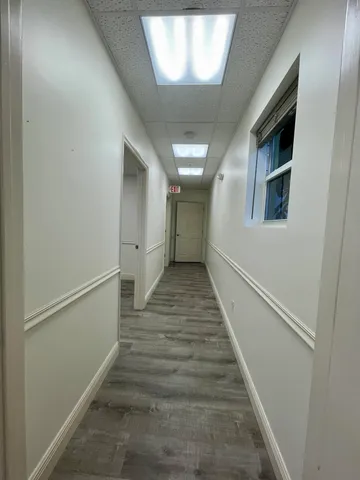 a view of a hallway with wooden floor and staircase