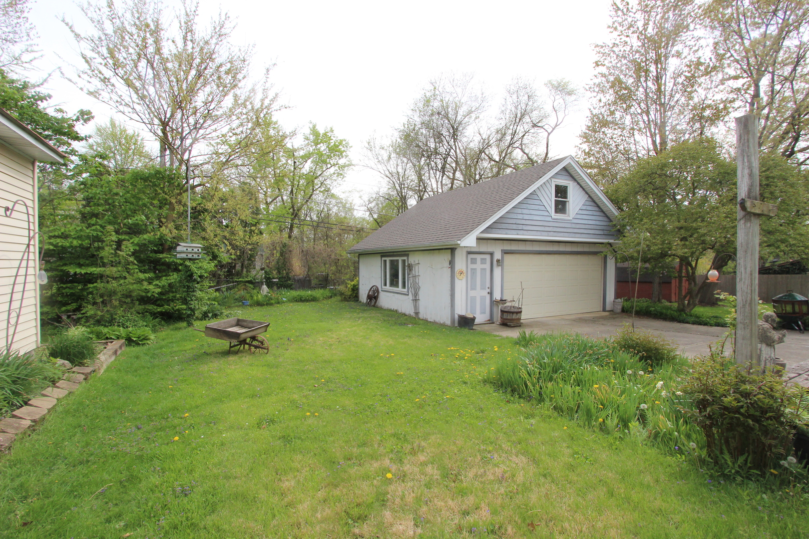 2457 Hawthorne Road Homewood, IL 60430 - Photo 19 of 20 a house that is sitting in the grass with large trees and plants