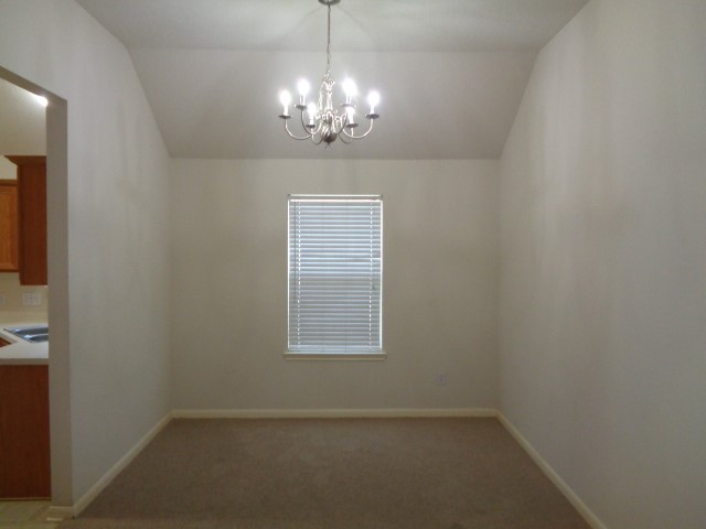 17136 Gleneagle Drive South Conroe, TX 77385 - Photo 8 of 19 en empty room with windows and chandelier