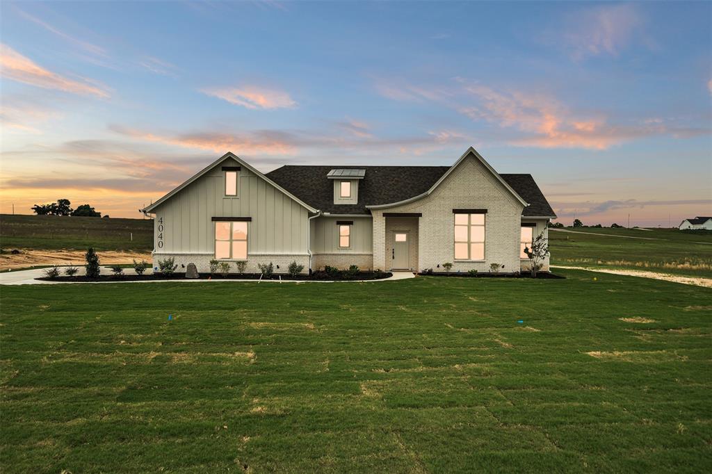a front view of a house with a yard and trees