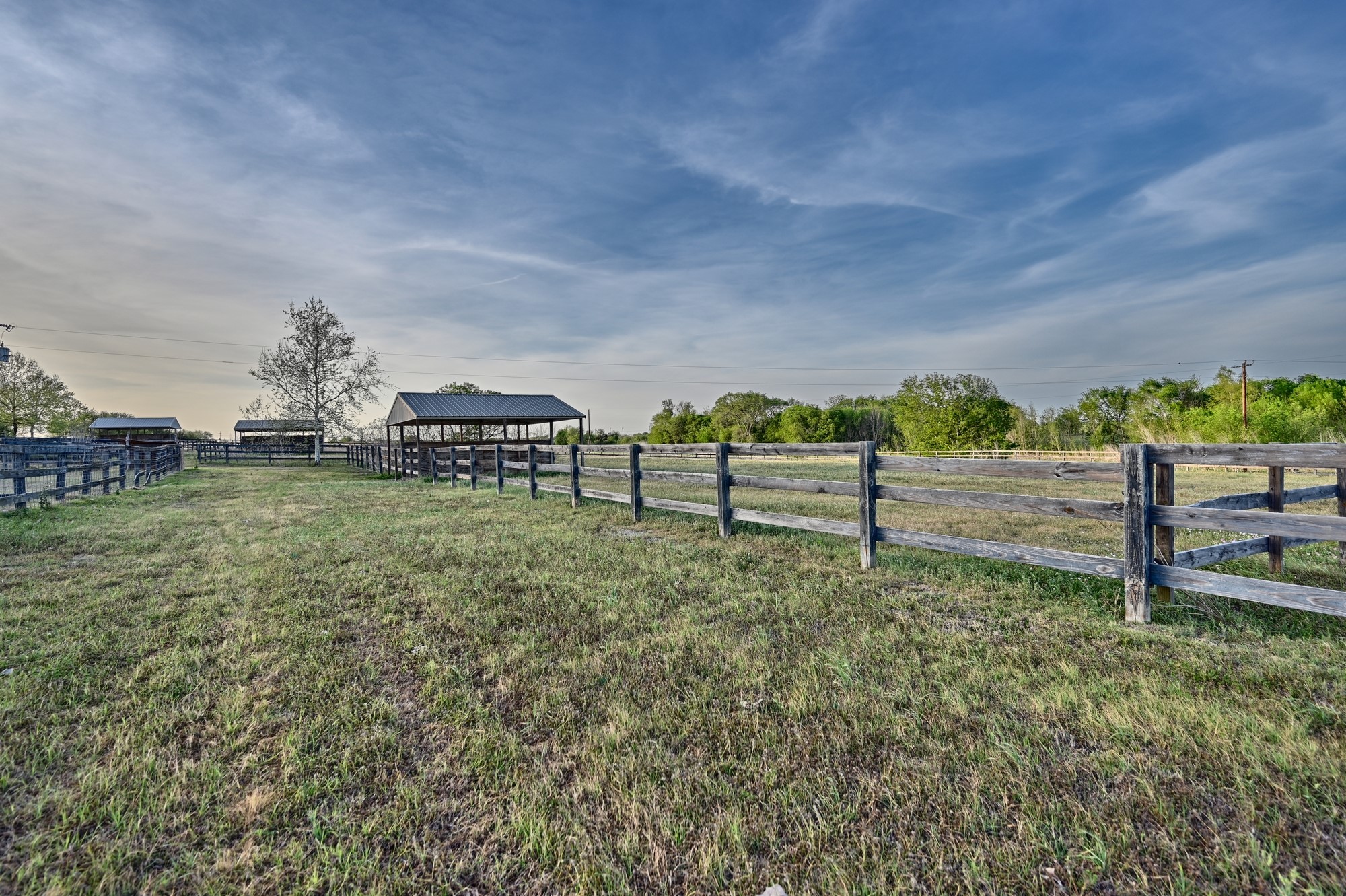5255 Ganske Road Burton, TX 77835 - Photo 26 of 46 Cross fenced pastures throughout property with a barn structure, surrounded by lush greenery and trees, ideal for outdoor activities and livestock.