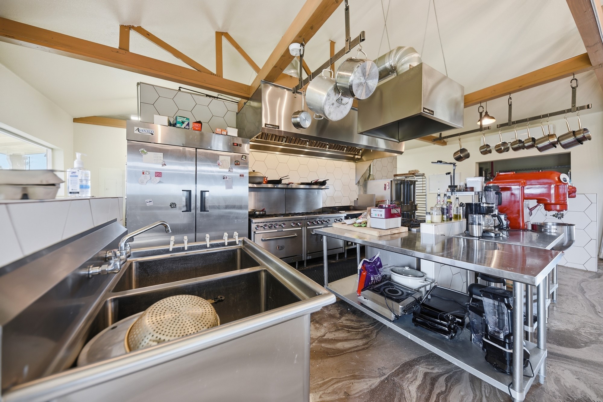 5255 Ganske Road Burton, TX 77835 - Photo 33 of 46 Equipped for large-scale cooking. It features stainless steel appliances, ample counter space, and a variety of cookware, ideal for culinary enthusiasts.