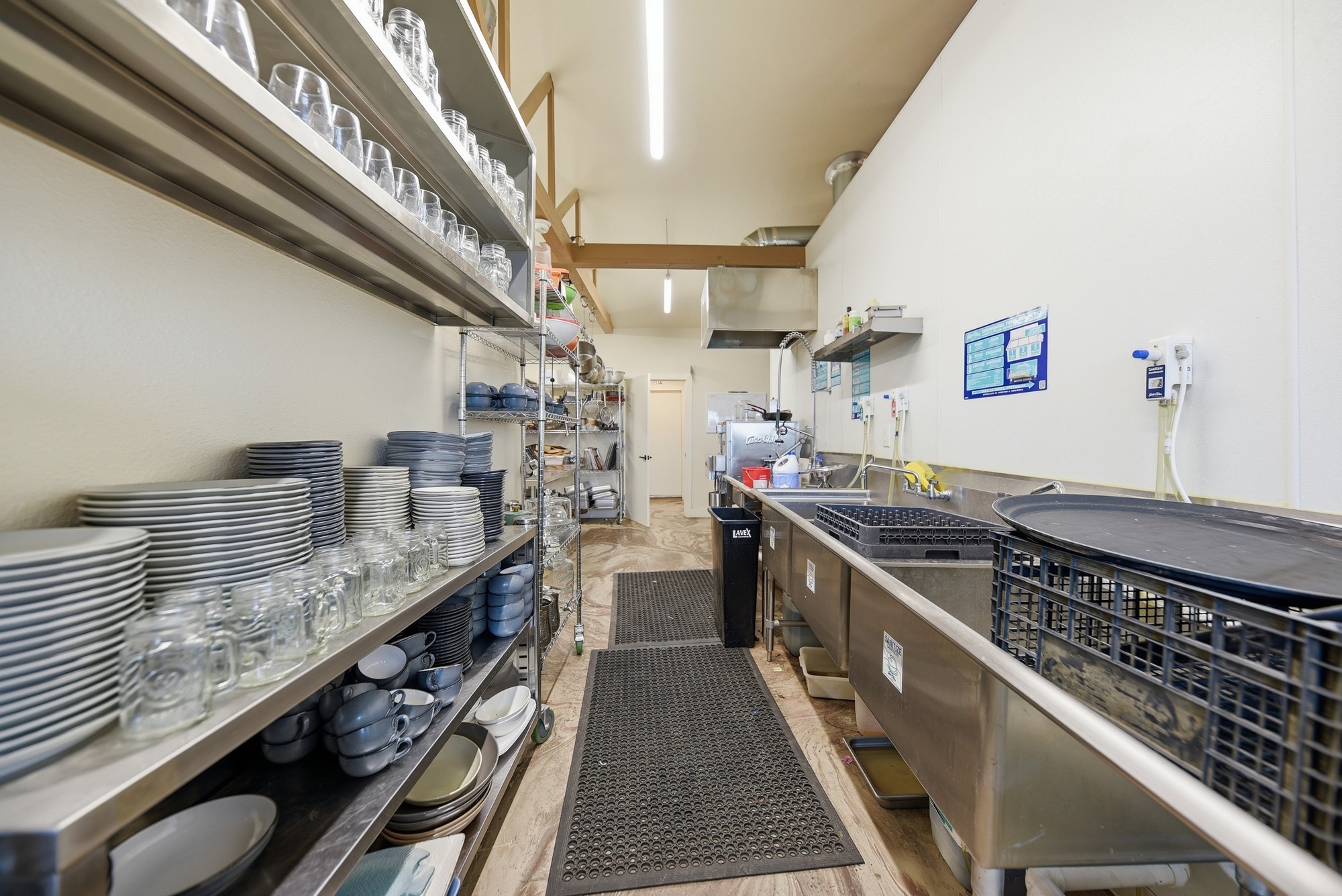 5255 Ganske Road Burton, TX 77835 - Photo 34 of 46 Commercial kitchen with ample shelving for dishes, stainless steel sinks, and a clean, organized layout. It's ideal for those looking for functional and spacious kitchen facilities.