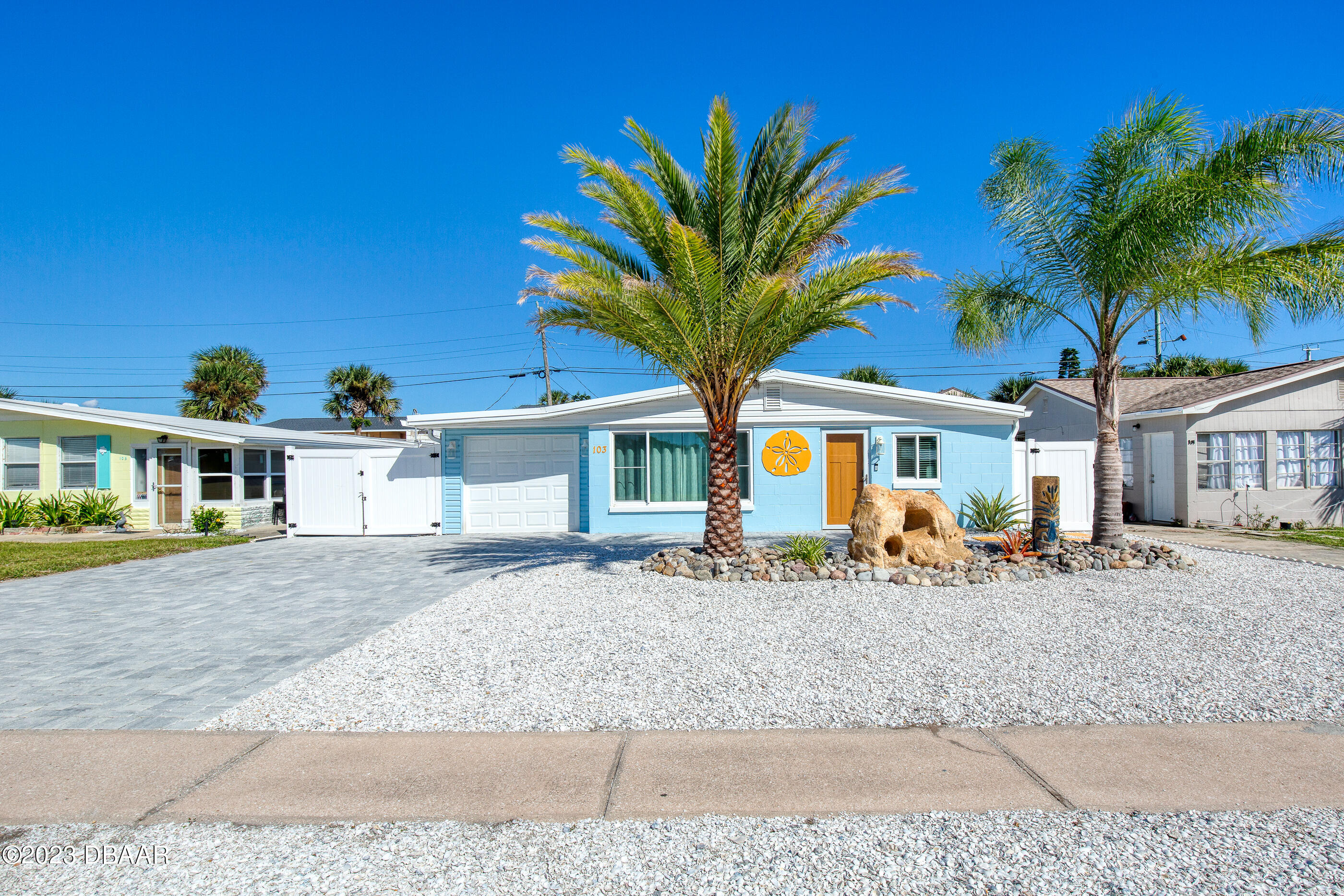 a front view of a house with a tree