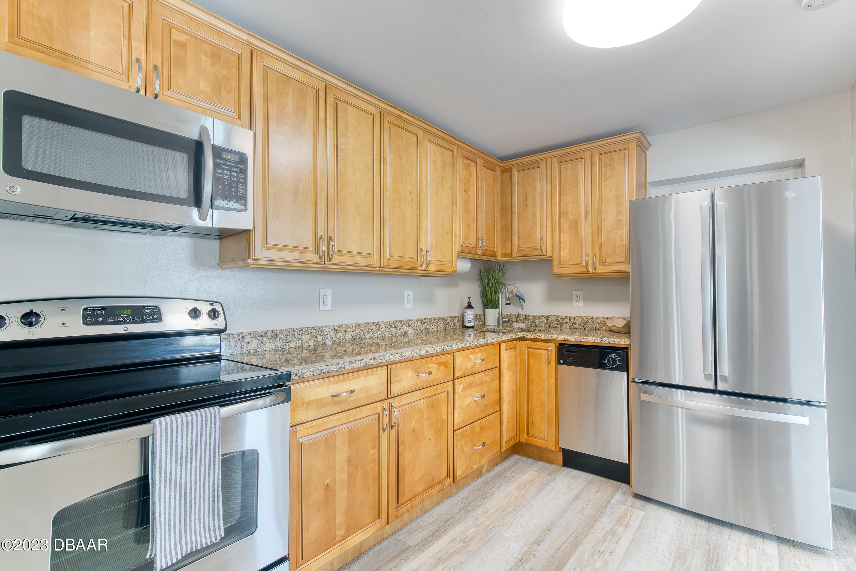 103 Roberta Road Ormond Beach, FL 32176 - Photo 13 of 56 a kitchen with stainless steel appliances granite countertop a stove a refrigerator and a microwave