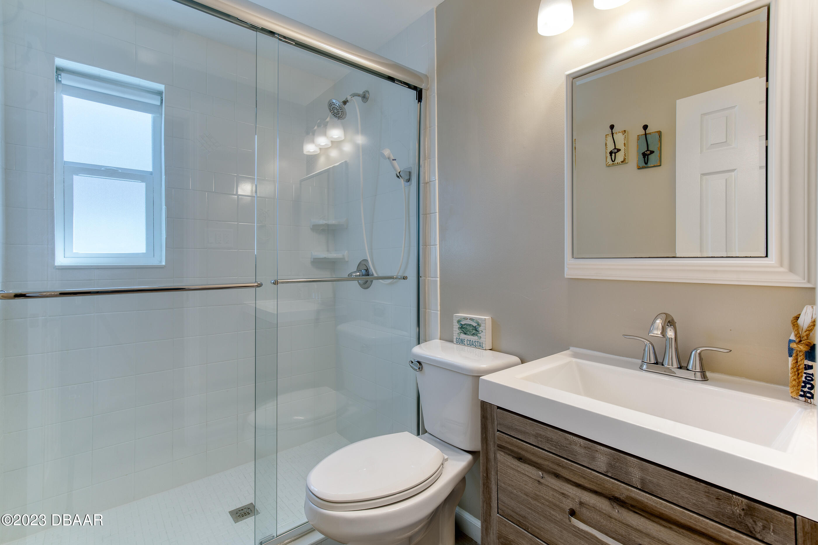 103 Roberta Road Ormond Beach, FL 32176 - Photo 18 of 56 a bathroom with a sink a toilet a shower and a mirror